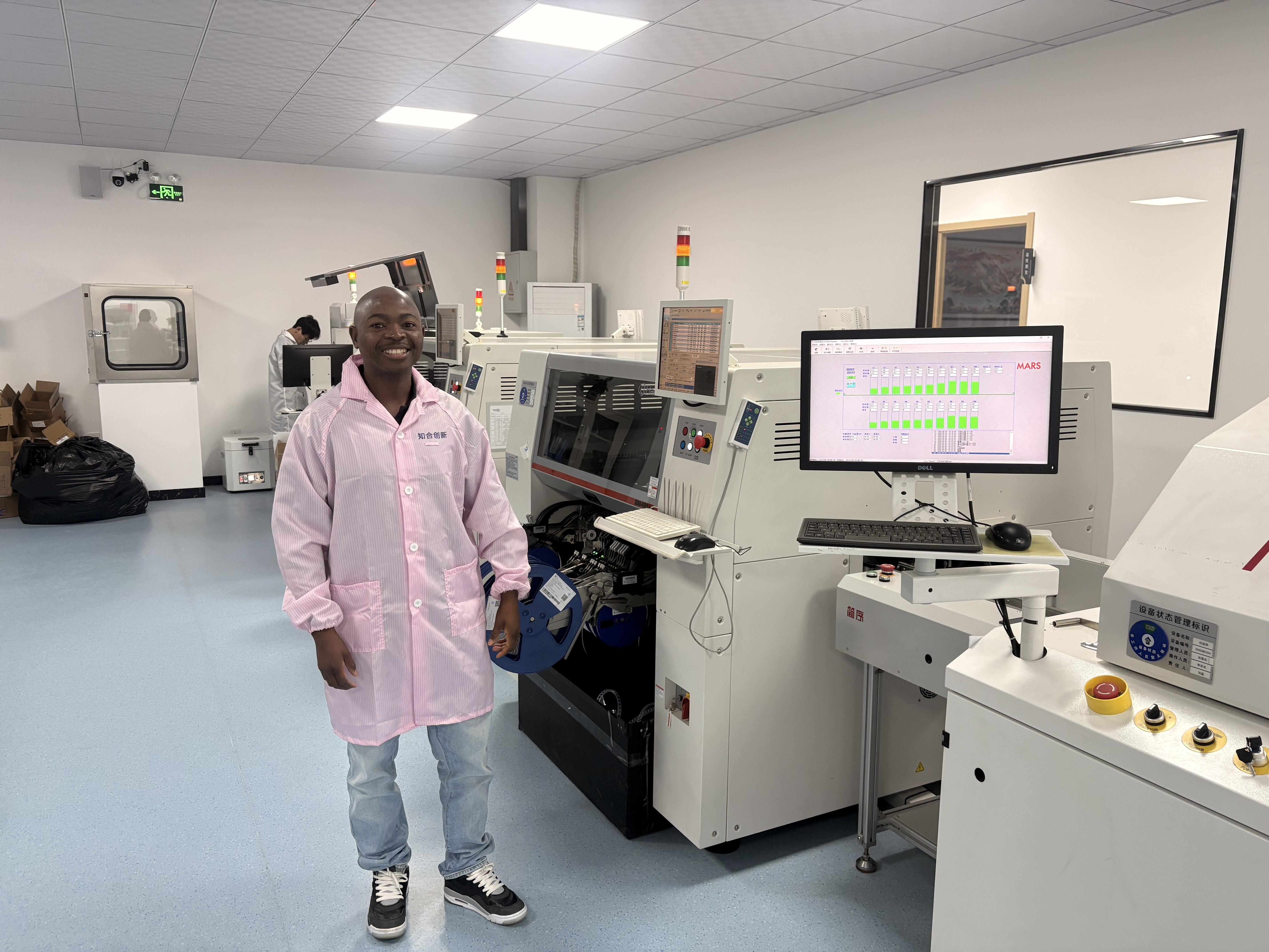 Siphiwe Mabusela, founder of AI Robotics Coding Academy Africa, beside electronics manufacturing equipment