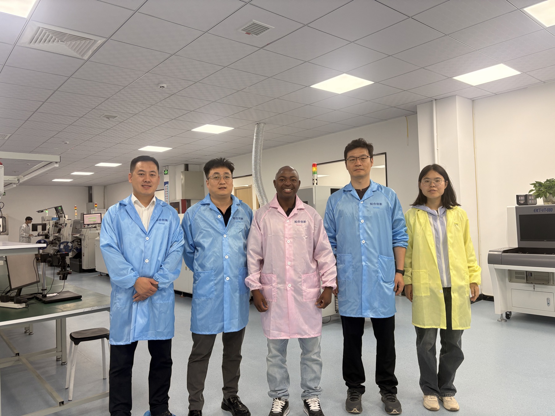 Group beside electronics manufacturing equipment during an industry visit